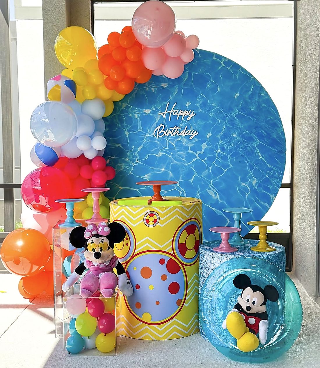 Mickey and Minnie pool party setup with round water backdrop