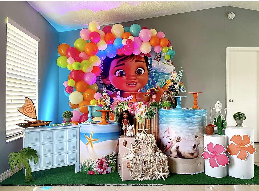 Tropical Moana baby birthday setup with bright balloon garland